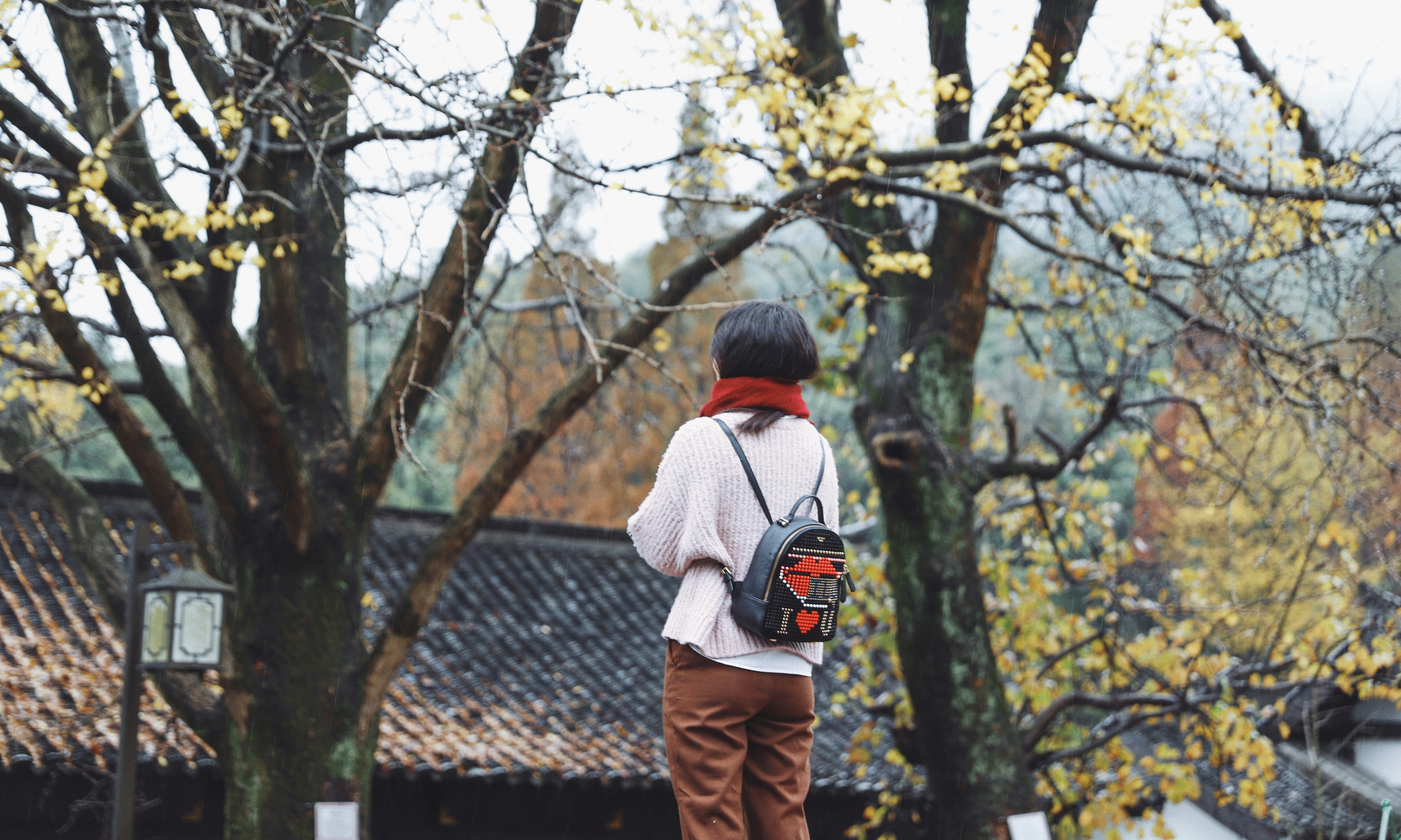 woman standing near trees and building